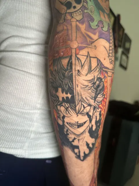 Anime leg tattoo of a black horned figure with a sword and a pirate flag above