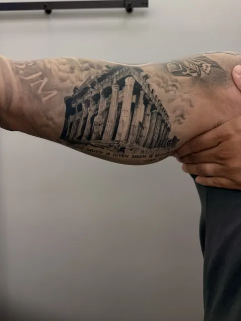 The black and grey Parthenon on the inner forearm, photographed fully healed