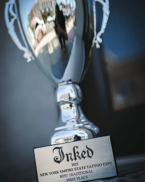 El trofeo Inked del NY Empire State Tattoo Expo 2022, con la placa grabada Best Traditional, First Place