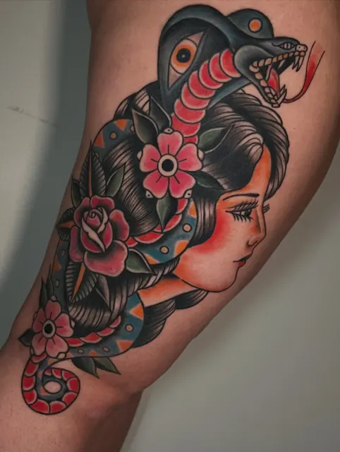 Tatuaje American Traditional de un rostro de mujer rodeado por una cobra y rosas rojas, la pieza que ganó el 1.er lugar Best Traditional en el Meadowlands Tattoo Arts Festival 2026